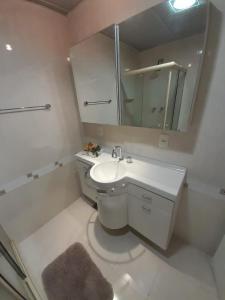 Baño blanco con lavabo y espejo en Lindo apartamento com 2 suites, en Río de Janeiro