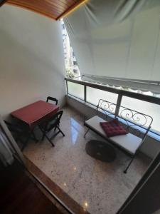 Habitación con mesa y banco en el balcón. en Lindo apartamento com 2 suites, en Río de Janeiro