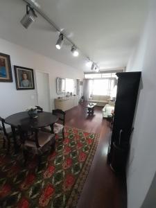 sala de estar con mesa y alfombra en Lindo apartamento com 2 suites, en Río de Janeiro