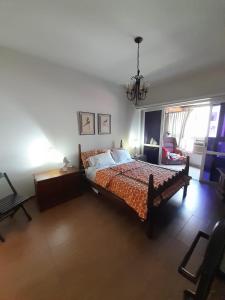 1 dormitorio con cama y lámpara de araña en Lindo apartamento com 2 suites, en Río de Janeiro