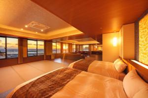 a bedroom with two beds and a view of the ocean at Kichimu in Kamogawa
