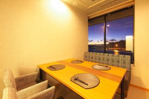 una mesa amarilla y sillas en una habitación con ventana en Kichimu, en Kamogawa