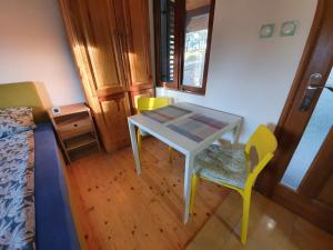 Zimmer mit einem Tisch, einem Stuhl und einem Bett in der Unterkunft Bungalov Zahej Divčibare in Divčibare