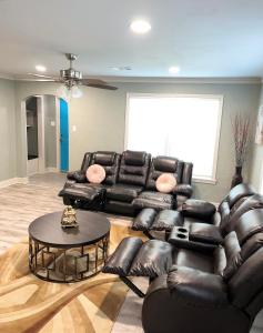a living room with a leather couch and a table at MIKA SPRINGS Beach Inspired Home! in Memphis