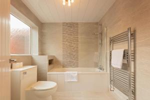 a bathroom with a toilet and a tub and a sink at The Stanley Spacious Modern Home Near the Beach perfect for a family holiday or Contractor stay in Blythe