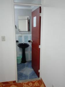 a bathroom with a toilet and a red door at Posada Turística Estancia Real in Sutamarchán