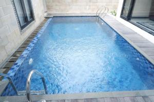 a swimming pool with blue water in a building at Blue Villa in Balikpapan