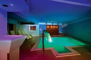 a swimming pool with a slide in a room at Hotel Ferretti in Diamante