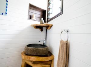 a bathroom with a stone sink and a mirror at Vakanananu Retreat in Matei