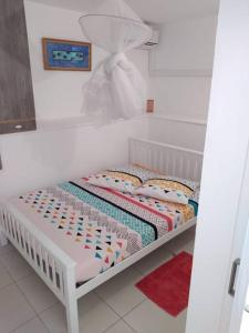 - un petit lit blanc dans une chambre dans l'établissement Villa Campêche Azur, au Marin