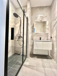 a bathroom with a shower and a white sink at Luxury Brand New Apartment in Brussels