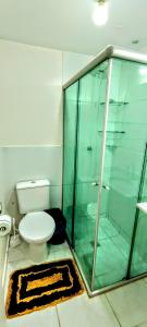 a bathroom with a toilet and a glass shower at Apartamento Aconchegante in Goiânia
