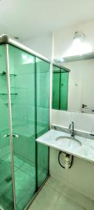 y baño con lavabo y ducha acristalada. en Apartamento Aconchegante en Goiânia