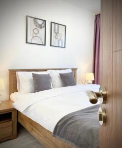 a bedroom with a bed with two pictures on the wall at Central Apartment for 4 Guests Next to State Opera in Stara Zagora +51 photos