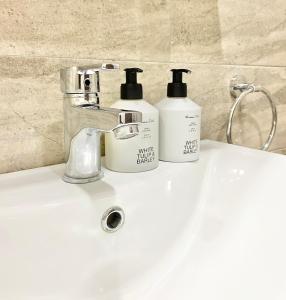 two bottles ofodorizers sitting on a bathroom sink at Central Apartment for 4 Guests Next to State Opera in Stara Zagora