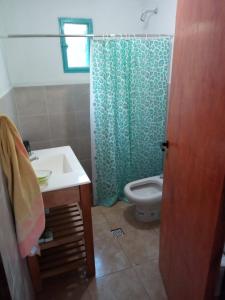 y baño con aseo y cortina de ducha. en La Higuerita 