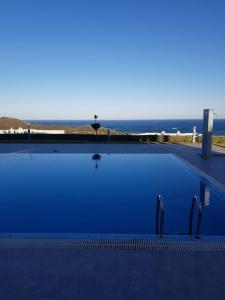 a blue swimming pool with a view of the ocean at A5 BELLA VISTA Cabo Negro Martil in Martil
