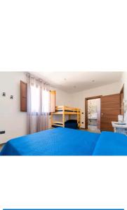 een slaapkamer met een bed met een blauwe sprei bij B&B L'Albero d'Oro in Sava