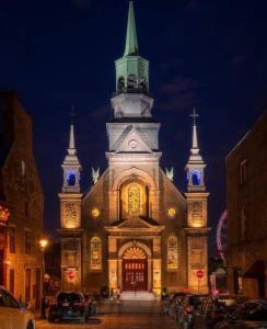 a large church with a tall tower at night at Heaven Is A Place On Earth in Montreal