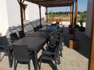 een lange tafel en stoelen op een patio bij B&B L'Albero d'Oro in Sava