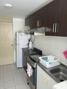 uma pequena cozinha com um lavatório e um frigorífico em Lindo Apartamento en Condominio Privado em Lima