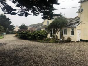 a house with a gravel driveway in front of it at Southcote Accommodation in Tintagel