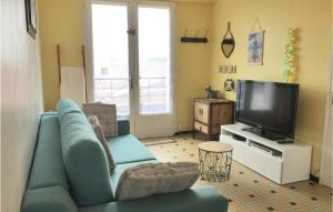 sala de estar con sofá azul y TV en Stunning Apartment In L Aiguillon Sur Mer With Kitchenette, en LʼAiguillon-sur-Mer
