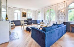Elle comprend un grand salon doté d'un mobilier bleu et de fenêtres. dans l'établissement Nice Home In Vieux Bourg With Kitchen, à Les Authieux-sur-Calonne