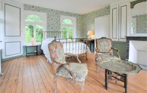 - une chambre avec un lit, deux chaises et une cheminée dans l'établissement Nice Home In Vieux Bourg With Kitchen, à Les Authieux-sur-Calonne
