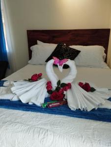 a bed with two swans made out of towels at Hospedaje La Galerie in Ciudad Cortés