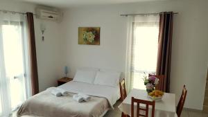 a bedroom with a bed and a table with chairs at Gregovic Apartments in Petrovac na Moru