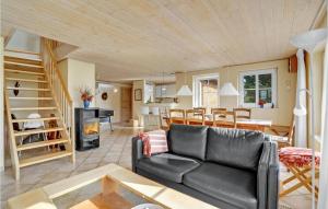 Awesome Home In Blvand With 5 Bedrooms, Sauna And Wifi في بلافاند: غرفة معيشة مع أريكة جلدية سوداء وطاولة