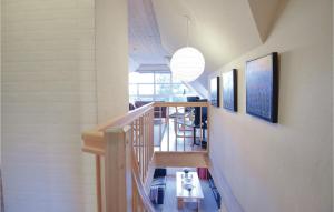 un couloir avec un escalier doté d'une table et de photos murales dans l'établissement 5 Bedroom Lovely Home In Blvand, à Blåvand
