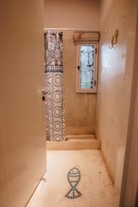 baño con ducha con un símbolo en el suelo en Amalia en San Rafael