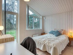 a bedroom with a bed and a large window at Holiday home Rørvig XVI in Rørvig