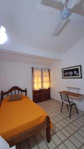 1 dormitorio con cama, mesa y ventilador de techo en La Toscana en Salta