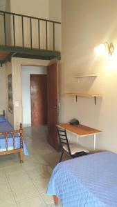 1 dormitorio con cama, mesa y escritorio en La Toscana en Salta