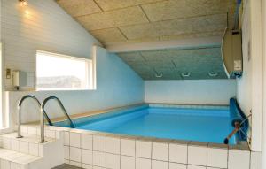 a large swimming pool in a room with a window at Awesome Home In Ringkbing Dk With Wifi in Søndervig