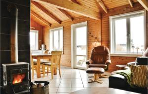 a living room with a fireplace in a log cabin at Awesome Home In Ringkbing Dk With Wifi in Søndervig