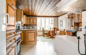 cocina con armarios de madera y comedor en 4 Bedroom Stunning Home In Lngserud en Eldansnäs