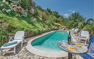a pool with a table and chairs and a bottle of wine at Il Casale Della Sabina in Magliano Sabina