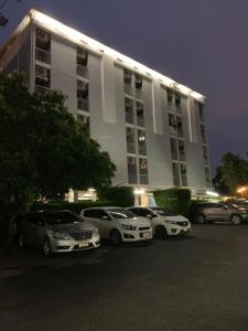 een parkeerplaats met auto's voor een gebouw bij Synsiri Ladprao 130 in Ban Bang Toei (1)