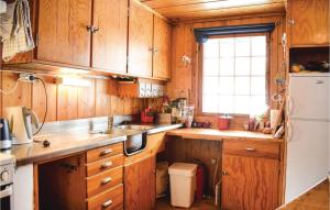 Una cocina con gabinetes de madera y un refrigerador blanco. en 5 Bedroom Stunning Home In Noresund, en Noresund