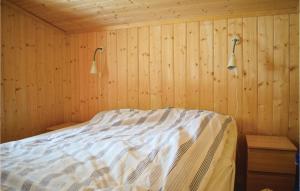 Un dormitorio con una cama en una pared de madera. en 5 Bedroom Stunning Home In Noresund, en Noresund