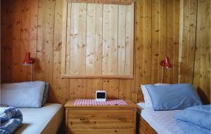 Un dormitorio con dos camas y una mesa con un iPod encima. en 5 Bedroom Stunning Home In Noresund, en Noresund 5 fotos más