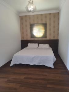 a bedroom with a white bed and a window at Kitnet na Rua Sapucai in Belo Horizonte