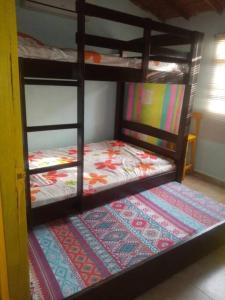 two bunk beds in a room with a rug at ¡VILLA AZUL! LUGAR ENCANTADOR A 60 METROS DEL MAR :o ;) in Necoclí