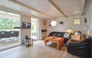Cozy Home In Rm With Kitchen في Toftum: غرفة معيشة مع أريكة جلدية وطاولة
