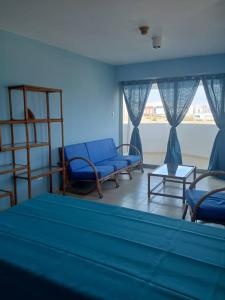 a room with a bed and two chairs and a table at *Tulli Apartmentos Margarita Island* in Porlamar