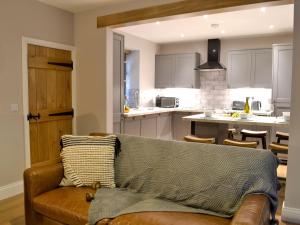 a living room with a couch and a kitchen at Terraughtie Cottage East-uk31767 in Terreglestown
